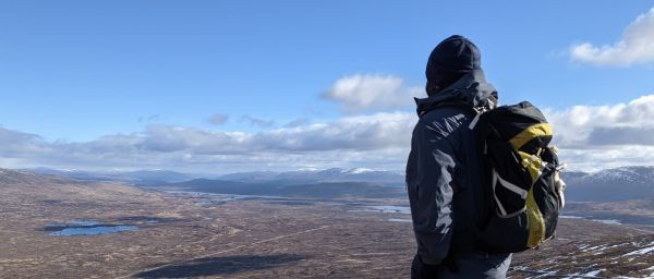 walker with backpack overlooking stunning landscape